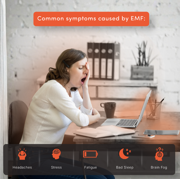 Woman is tired at her desk because of EMF exposure from laptop and phone